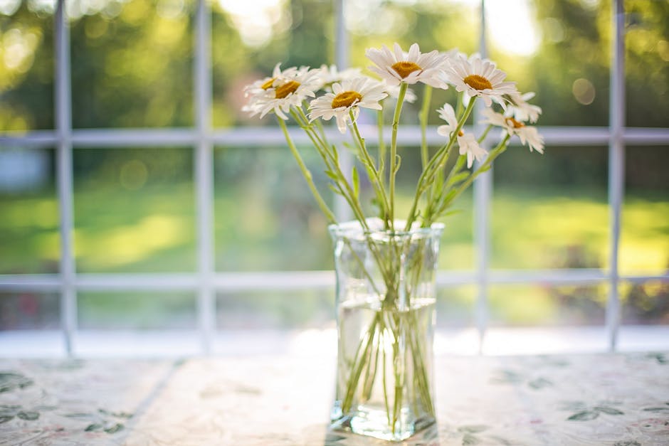 flowers in a vase in front of a window